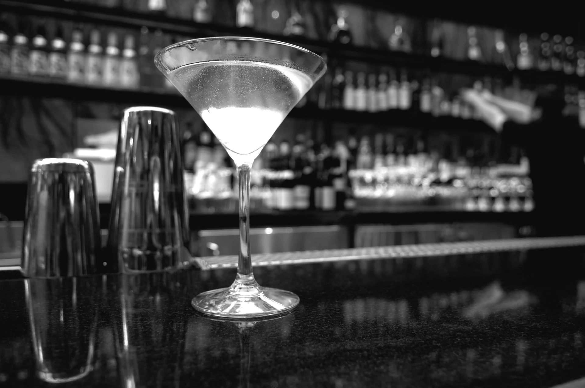 Un magnifique verre à cocktail sur un bar avec un shaker. Une illustration parfaite pour le Santeuil Café, le bar nantais spécialiste du cocktail avec et sans alcool. Un café de quartier convivial pour les habitués des bons moments.